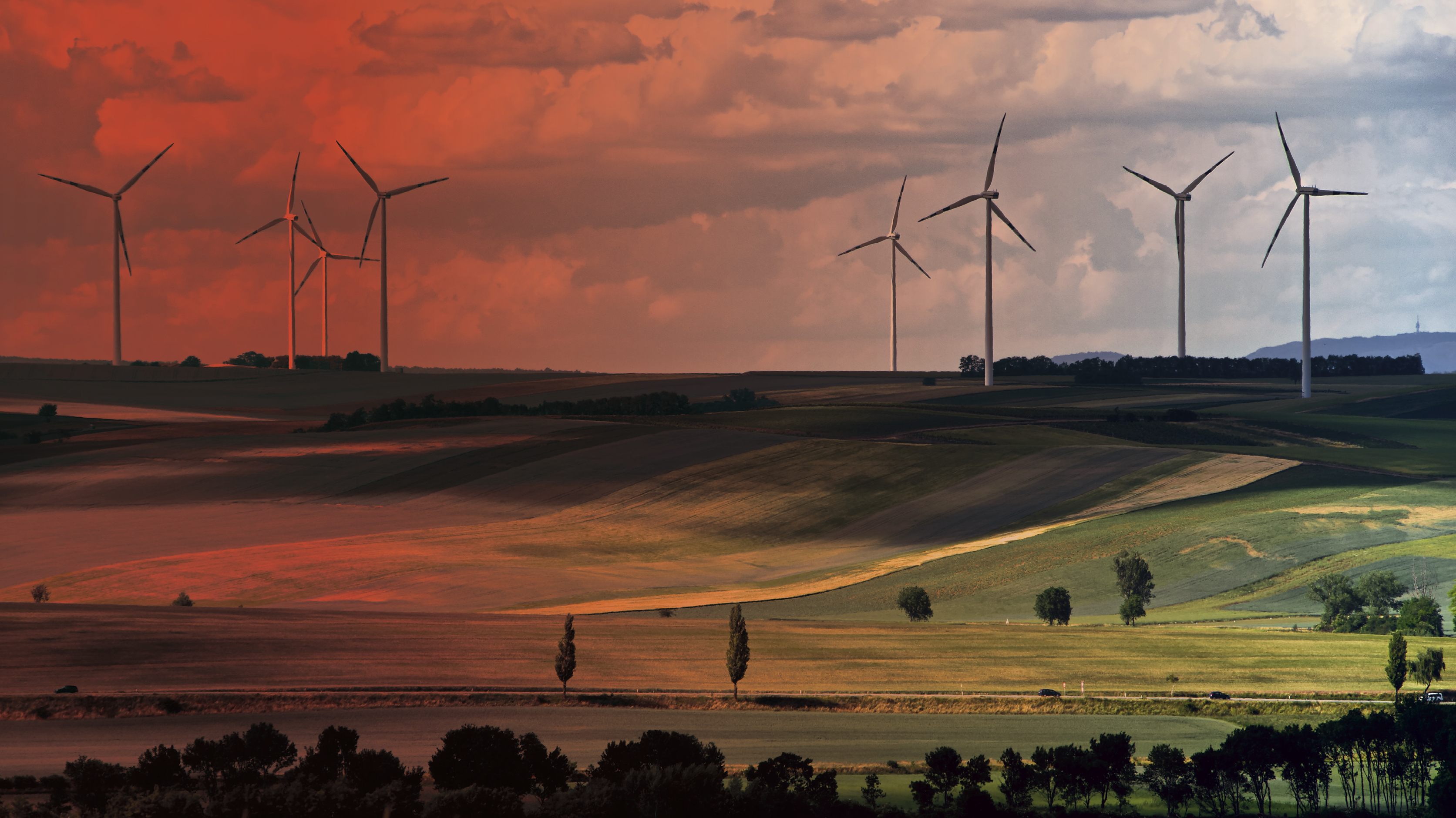 Windräder auf hügeliger Landschaft