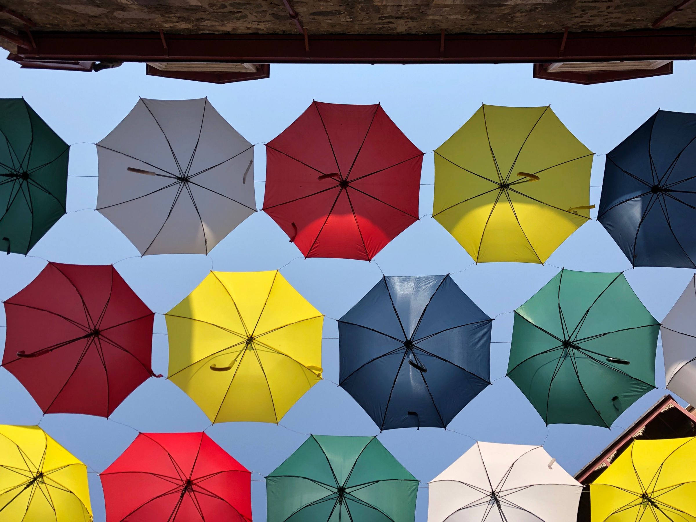 bunte Regenschirme vor Hauswand von unten