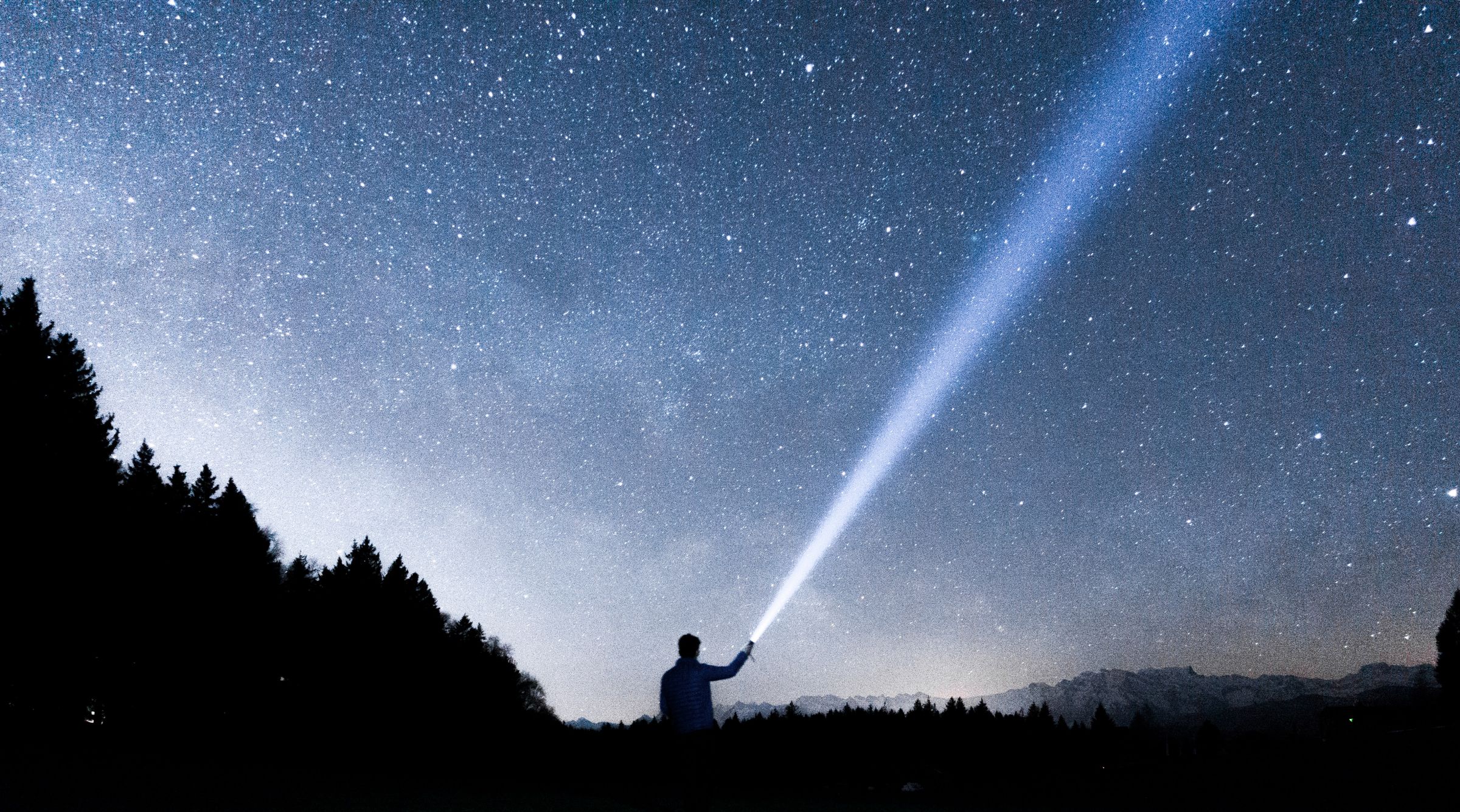 Mann mit Taschenlampe in der Natur