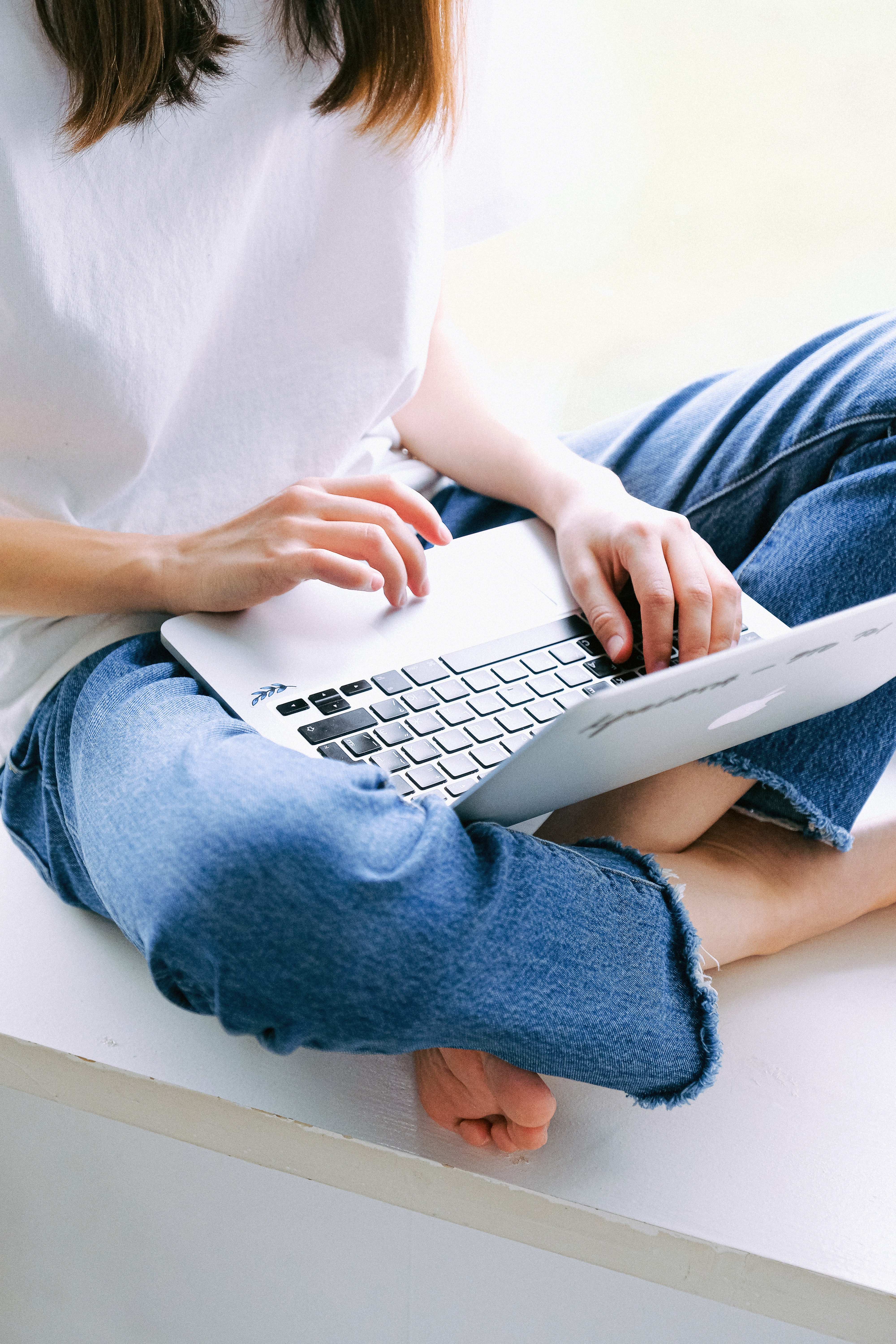 Frau im Schneidersitz mit Laptop