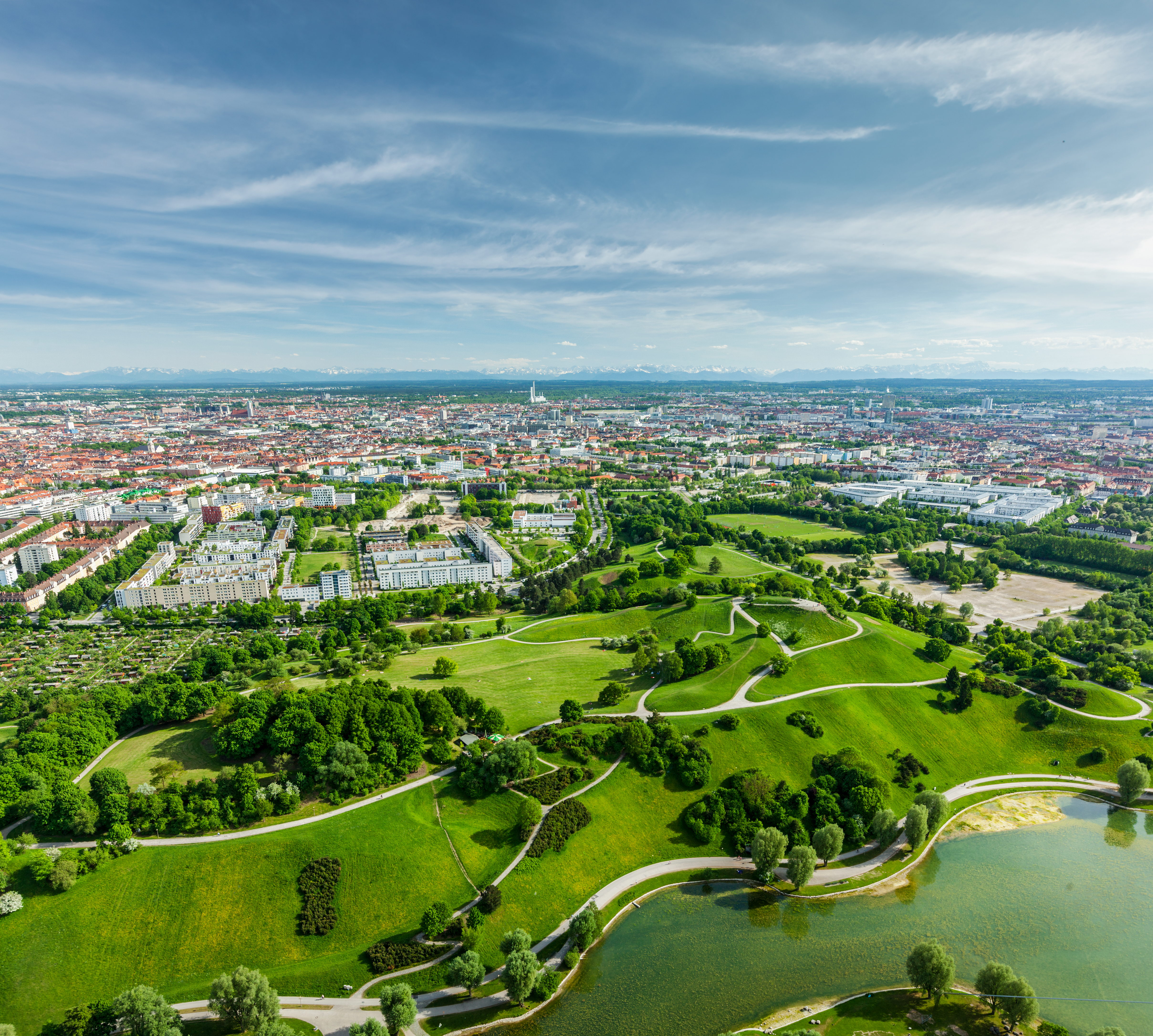 Landschaft mit grüner Wiese und Stadt im Hintergrund