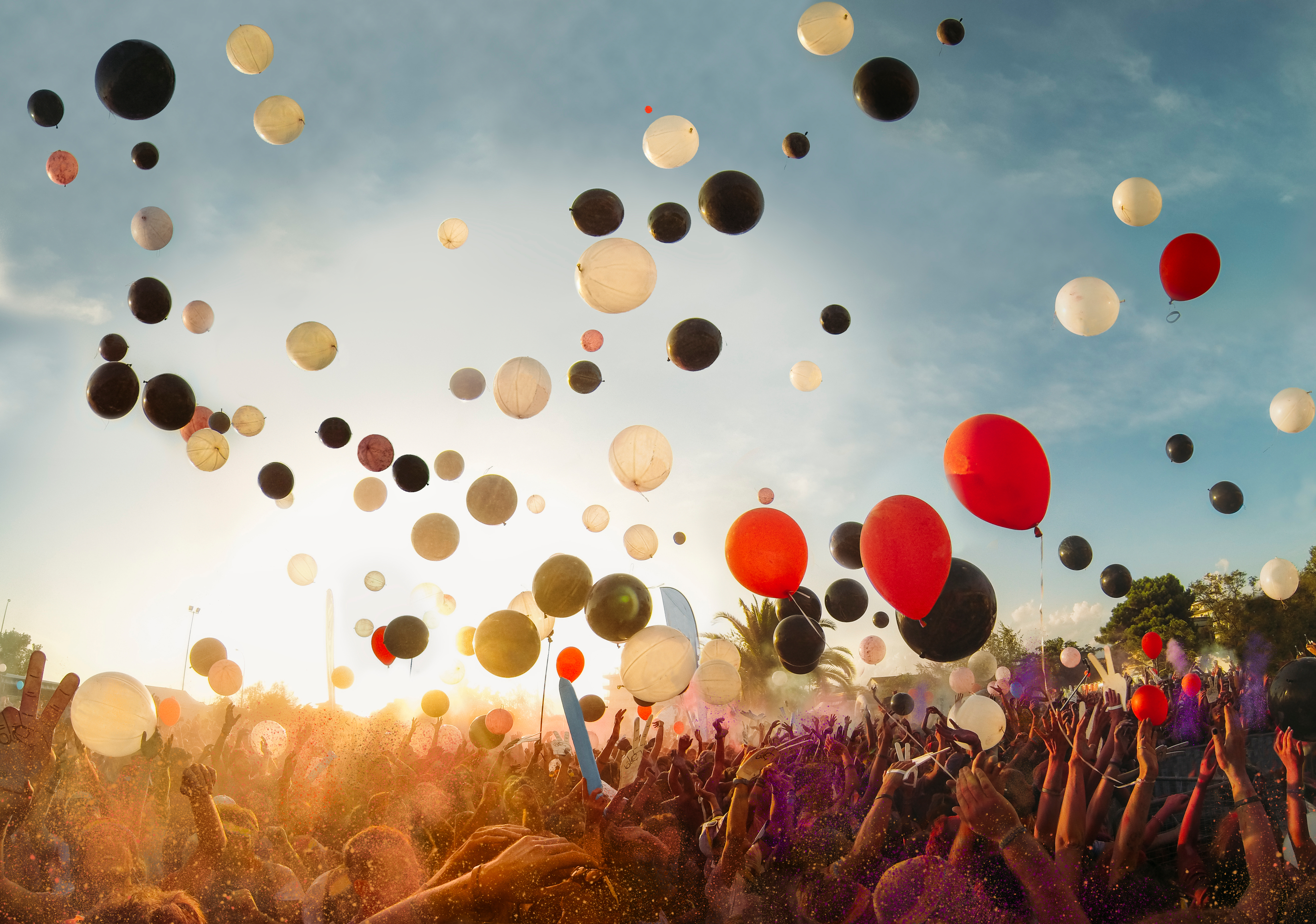 Bunte Luftballons steigen über Menschenmenge in die Luft