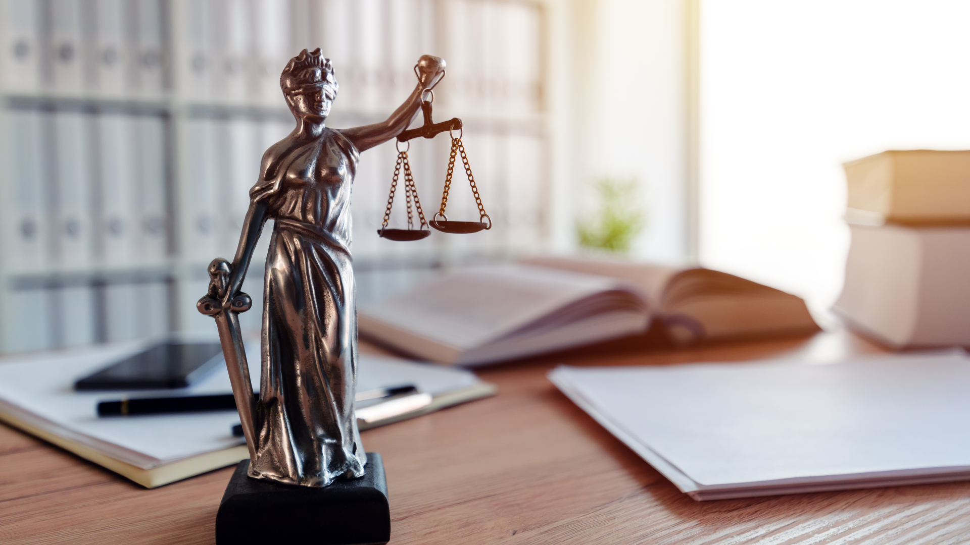 Justitia Statur steht auf einem Schreibtisch