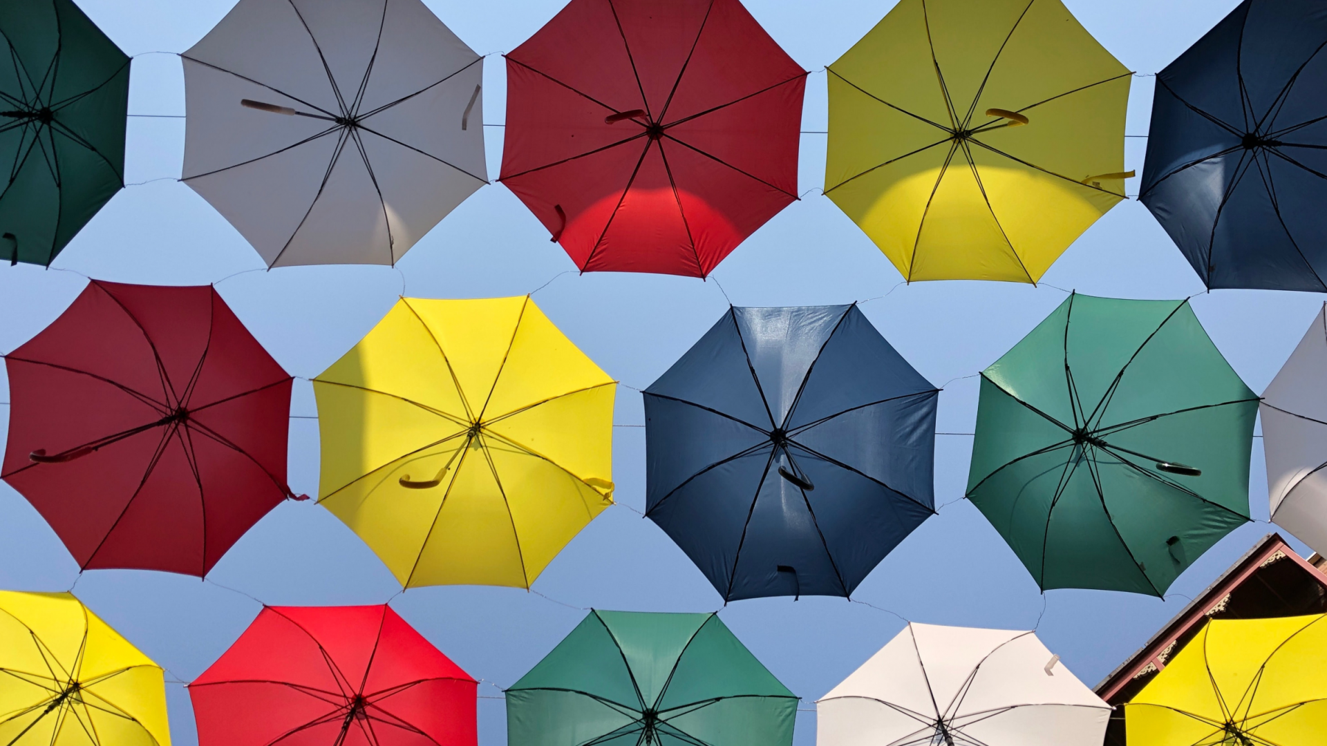 bunte Regenschirme vor Hauswand von unten