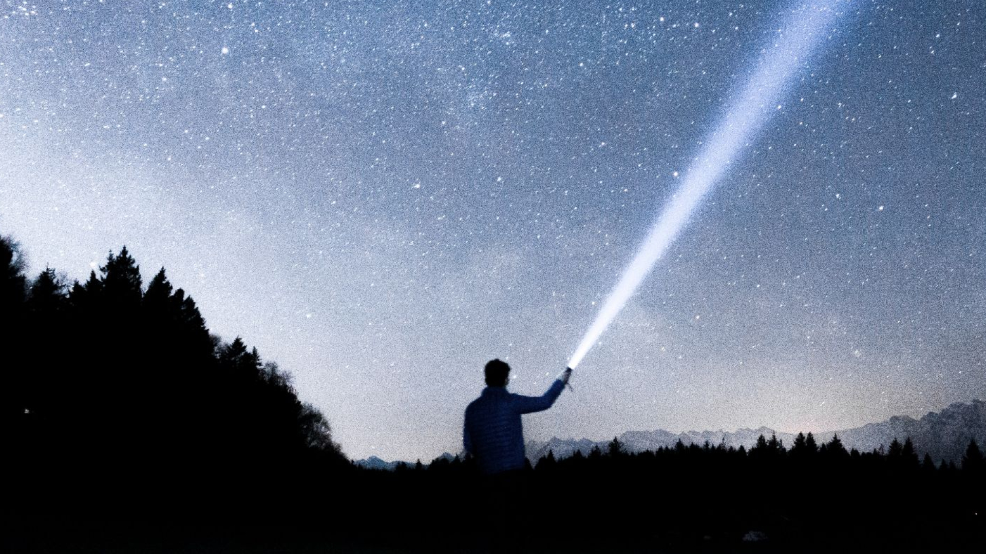 Mann mit Taschenlampe in der Natur