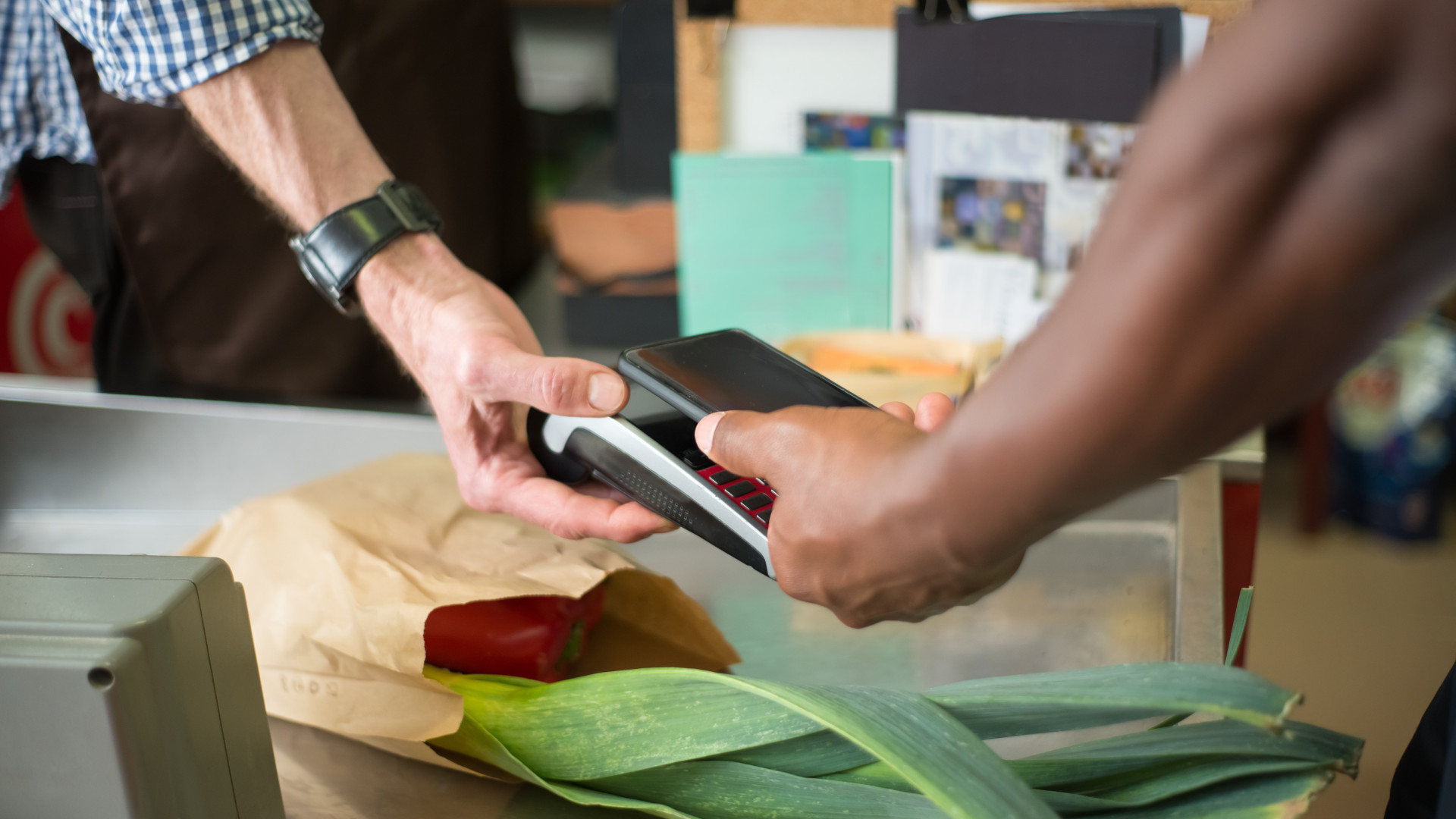 Mann bezahlt Gemüse mit Smartphone