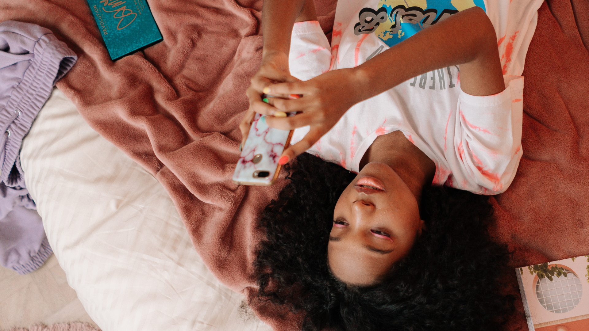 Teenager mit Smartphone im Bett
