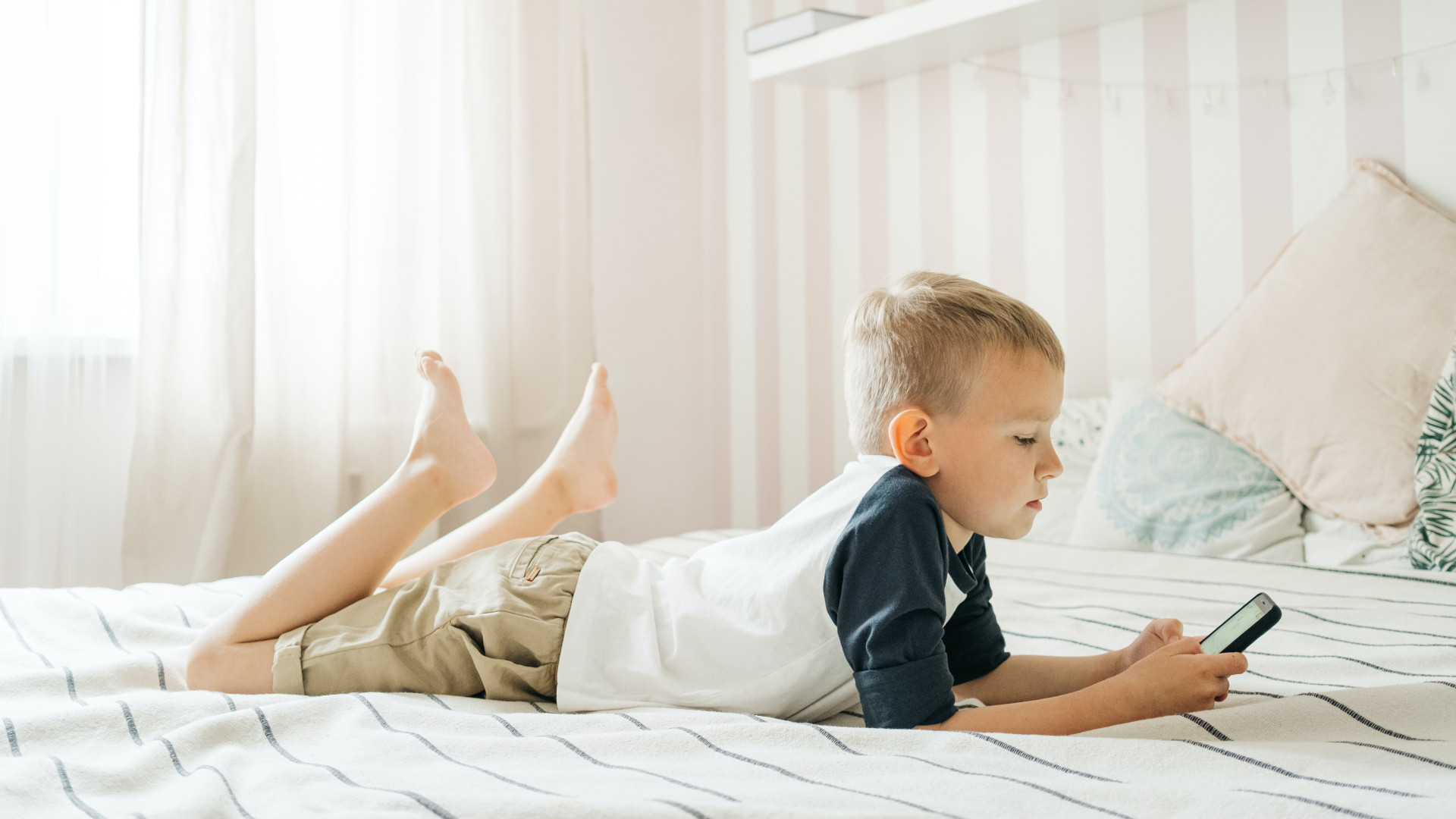 Junge im Bett mit Smartphone