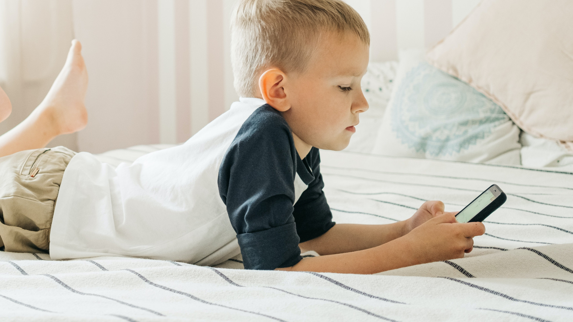 Junge im Bett mit Smartphone