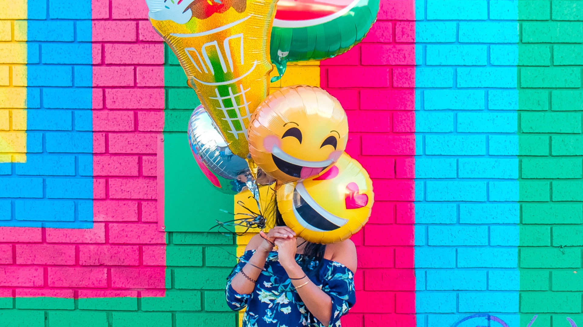 Frau mit Emoji-Luftballons