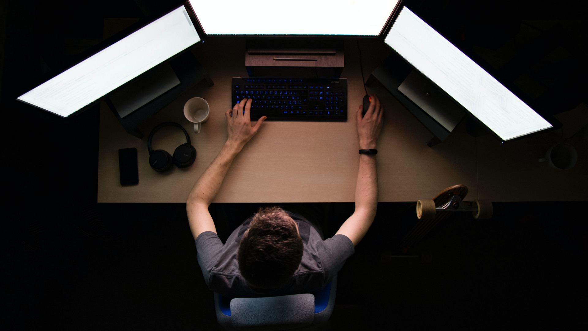 Programmierer mit drei Bildschirmen