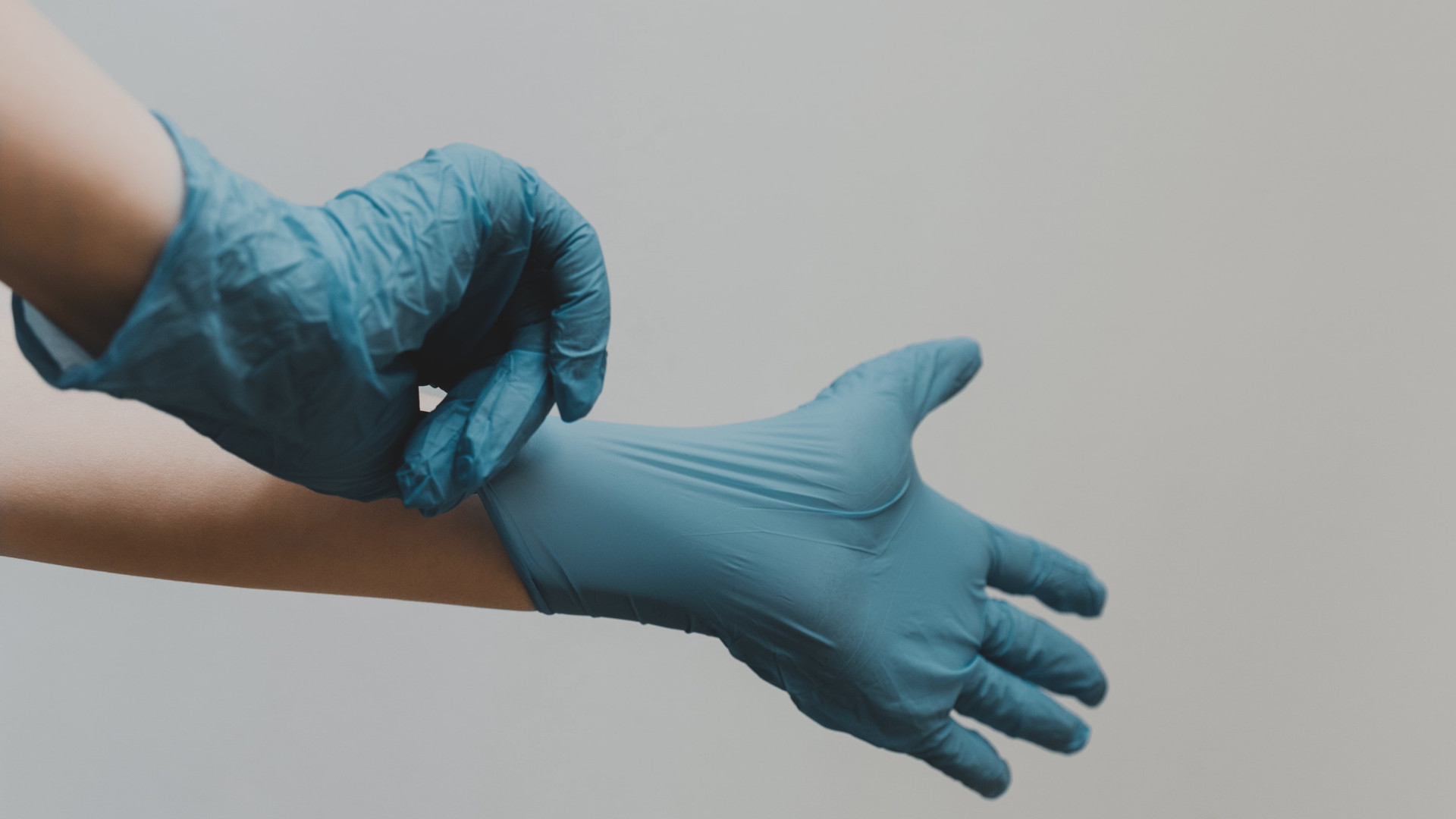 Pfleger zieht sich Handschuhe an