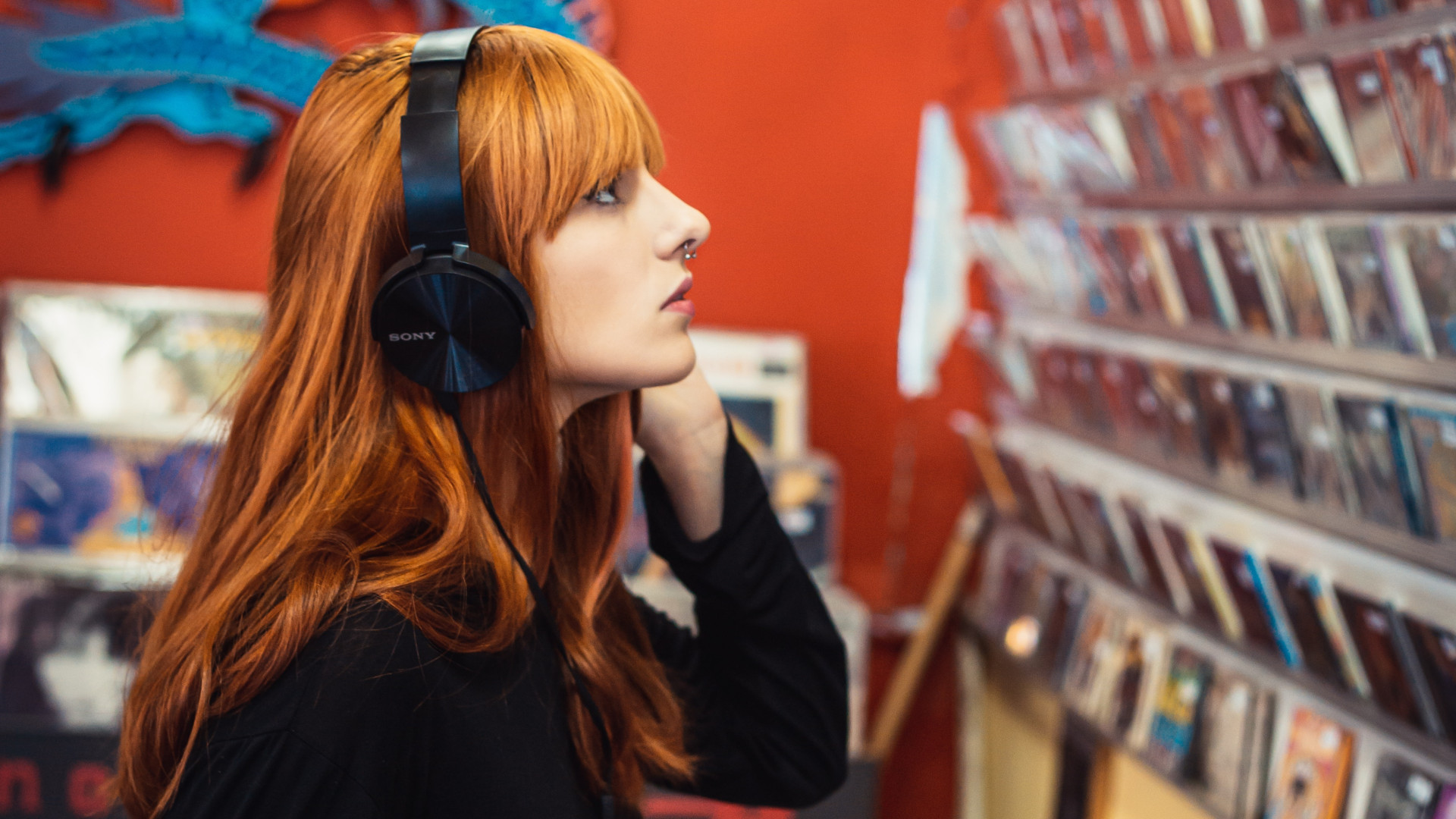 Frau hört im Plattenladen Musik