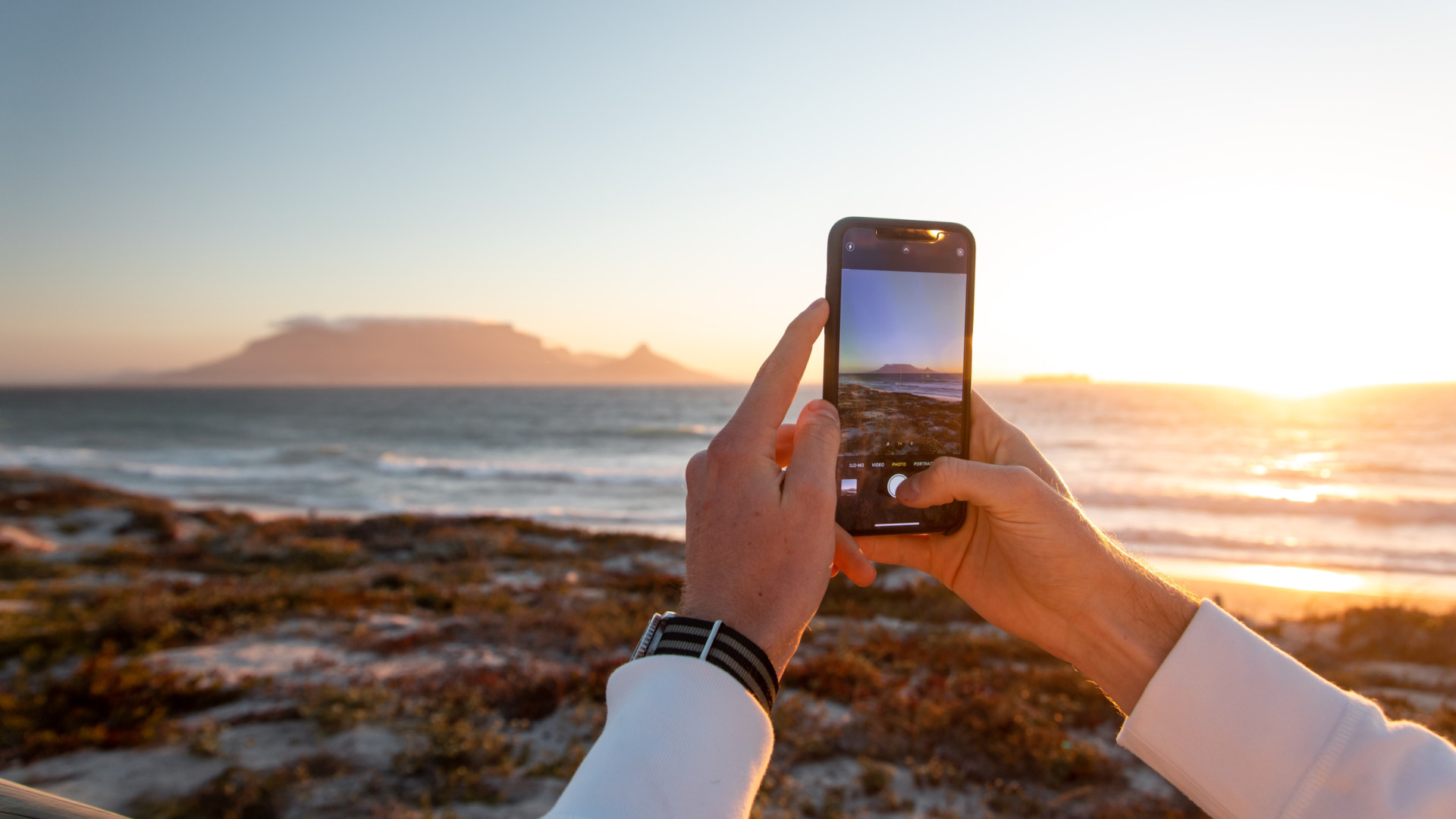 Person macht Foto am Strand