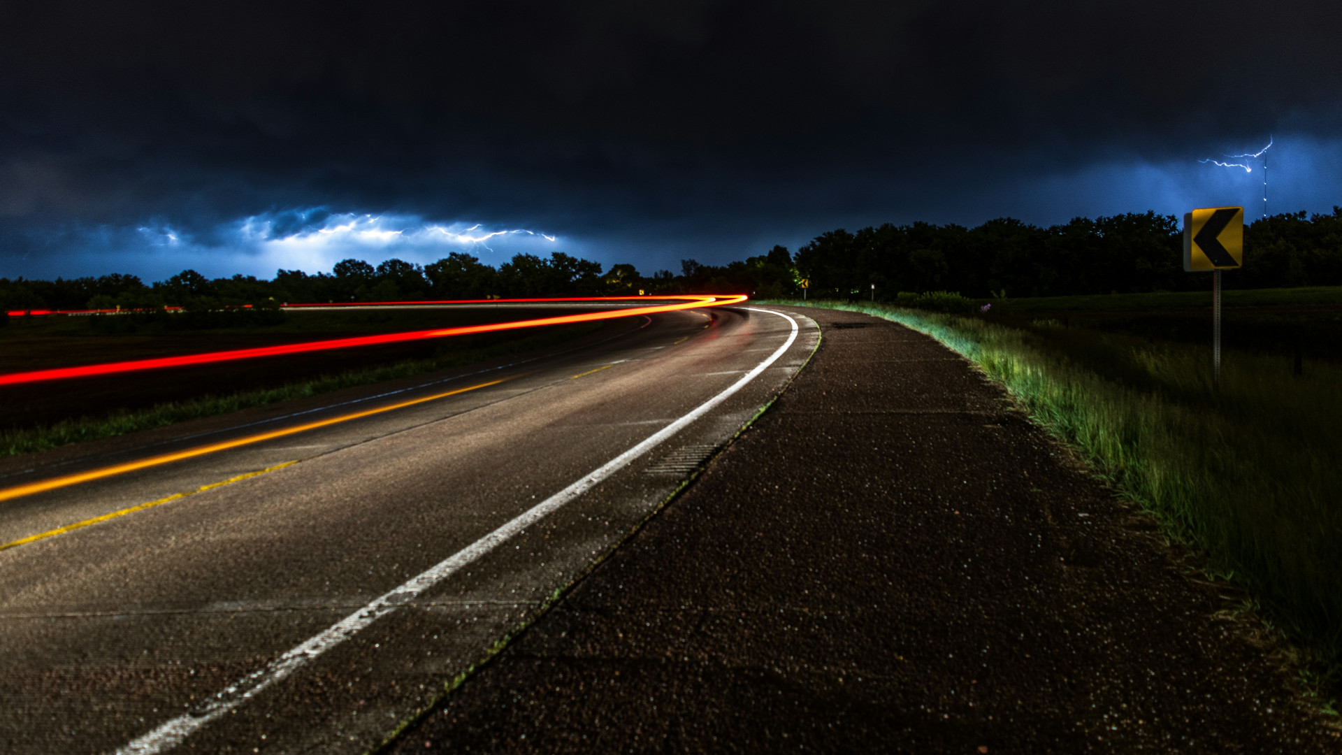 Straße mit Lichtspur die um die Ecke geht