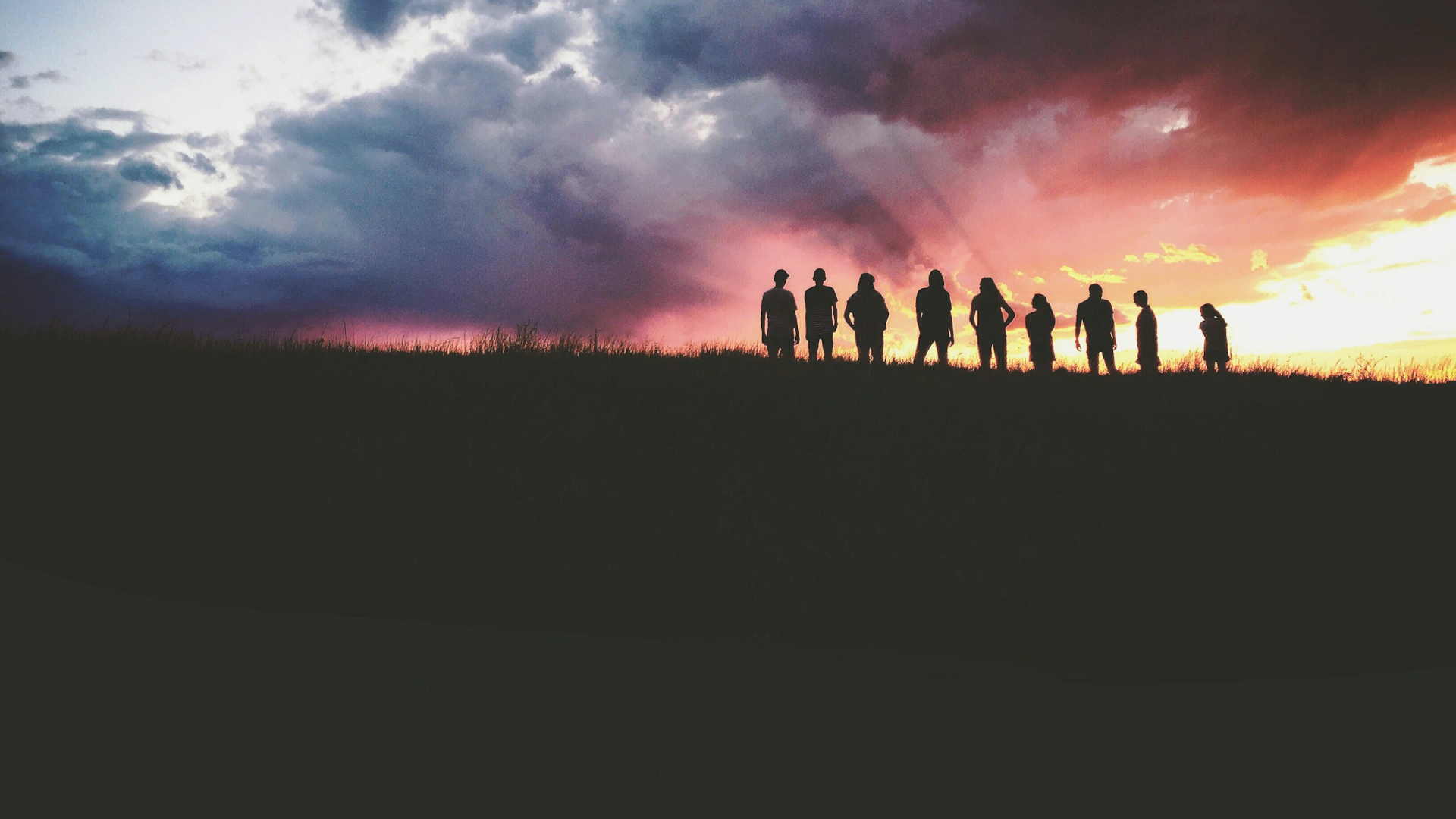 Gruppe von Menschen im Gegenlicht bei Sonnenuntergang