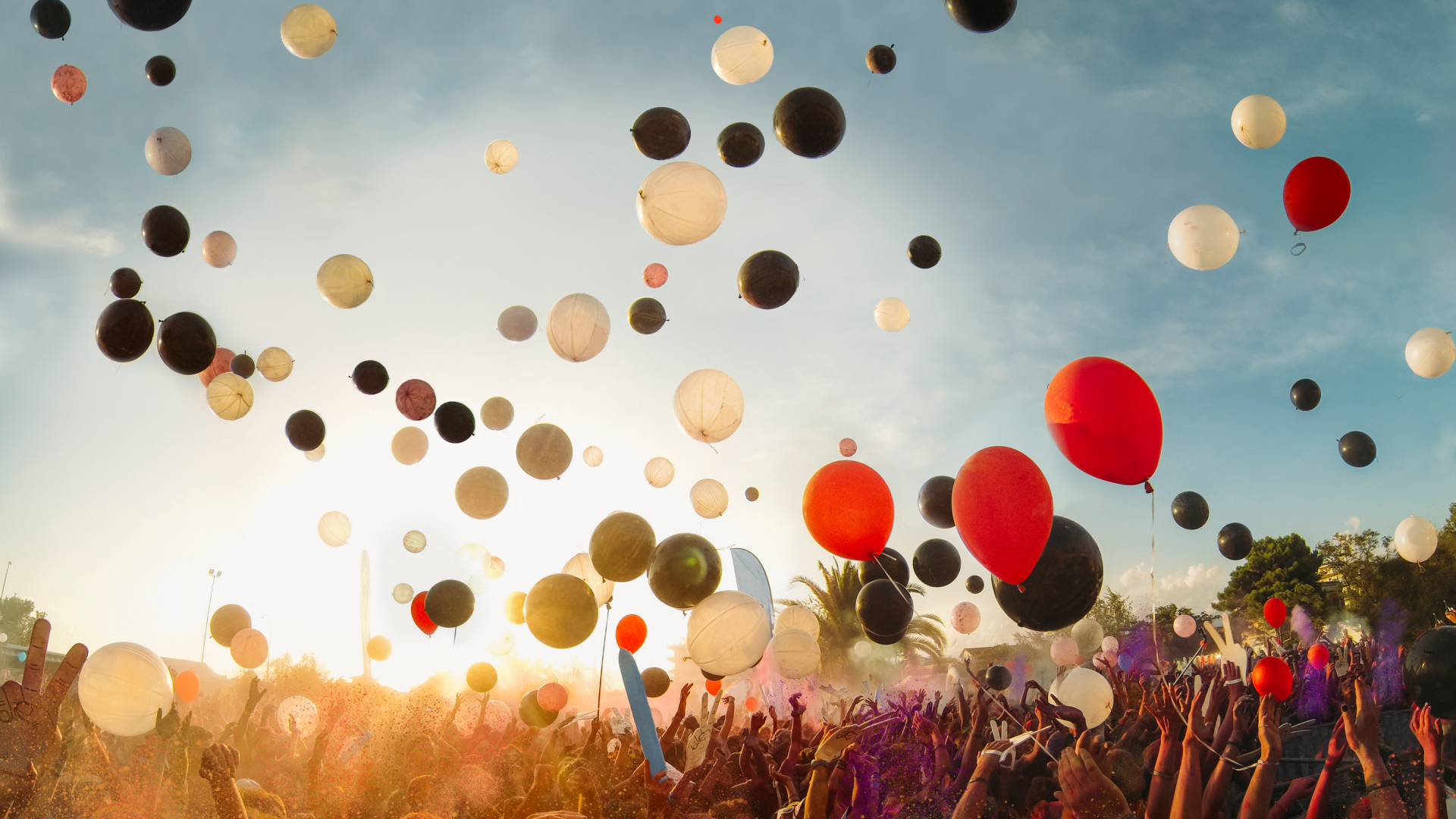 Bunte Luftballons steigen über Menschenmenge in die Luft