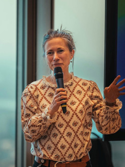 Valerie von Lucke mit Mikrofon in der Hand bei angeregtem Vortrag