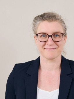 Dr. Katrin Nachtrab, Frau mit kurzen, hellen Haaren, dunkler Blazerjacke, lächelt in die Kamera. Heller Hintergrund.