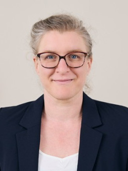 Dr. Katrin Nachtrab, Frau mit kurzen, hellen Haaren, schwarzer Blazer, weißem Oberteil, lächelt in die Kamera.