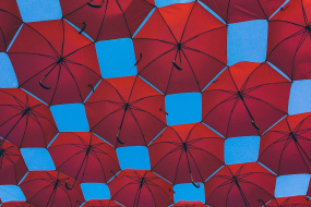 Rote Regenschirme vor blauem Himmel