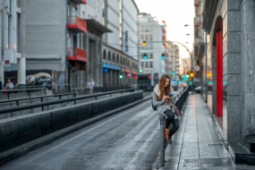 Frau sitzt auf der Straße und schaut in ihr Handy