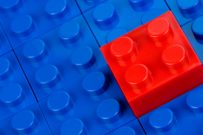 Legosteine in blau, einer in rot