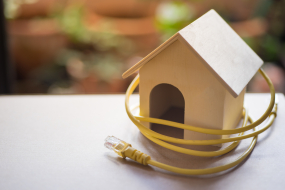 Kleines Holzhaus das mit gelben Kabel umwickelt ist