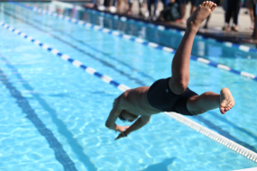 Mann springt in Schwimmbecken