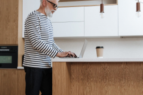 Älterer Mann zu Hause am Laptop