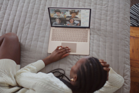 Frau videotelefoniert auf dem Bett