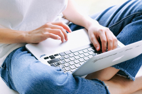 Frau im Schneidersitz mit Laptop