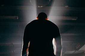 Mann mit breiten Schultern im Dunkeln