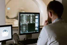 Arzt betrachtet Scan am Computer