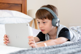 Junge mit Kopfhörern am Tablet