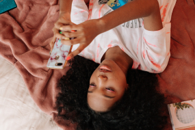 Teenager mit Smartphone im Bett
