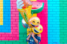 Frau mit Emoji-Luftballons