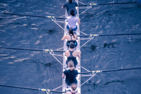 Frauen von hinten im Ruderboot