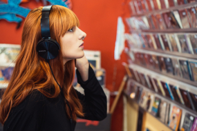 Frau hört im Plattenladen Musik