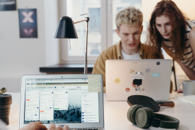 Junge Menschen arbeiten gemeinsam in einem Team an Laptops