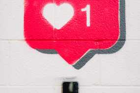 Handy und Likebutton auf einer Wand