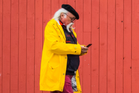 Senior schaut auf sein Handy im Laufen