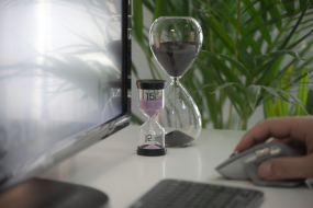 Arbeitsplatz mit Sanduhren und Computermaus