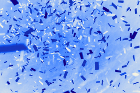 Blau-weiße Konfettistreifen fliegen in großer Zahl durch einen hellblauen Hintergrund.
