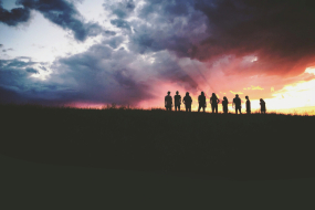 Gruppe von Menschen im Gegenlicht bei Sonnenuntergang