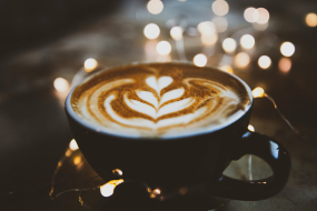 Cappuccino mit Latte-Art und Lichterdekoration