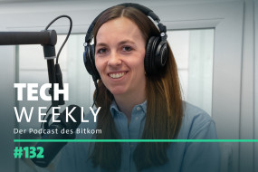 Person mit Kopfhörern spricht ins Mikrofon, trägt hellblaues Hemd. Hintergrund: helle Wände, Fenster. Text: "TECH WEEKLY", "Der Podcast des Bitkom", "#132".