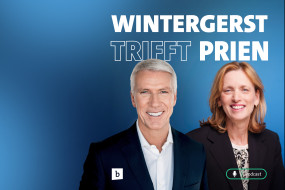 Mann mit grauen Haaren und Frau mit braunen Haaren vor blauem Hintergrund, Text: „WINTERGERST TRIFFT PRIEN“, Mikrofon-Symbol.