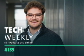 Lächelnder Mann mit lockigem, braunem Haar und Brille, vor unscharfem Hintergrund. Text: „TECH WEEKLY“ und „#135“.
