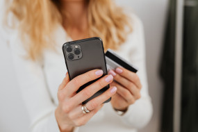 Frau mit Handy & Karte in der Hand